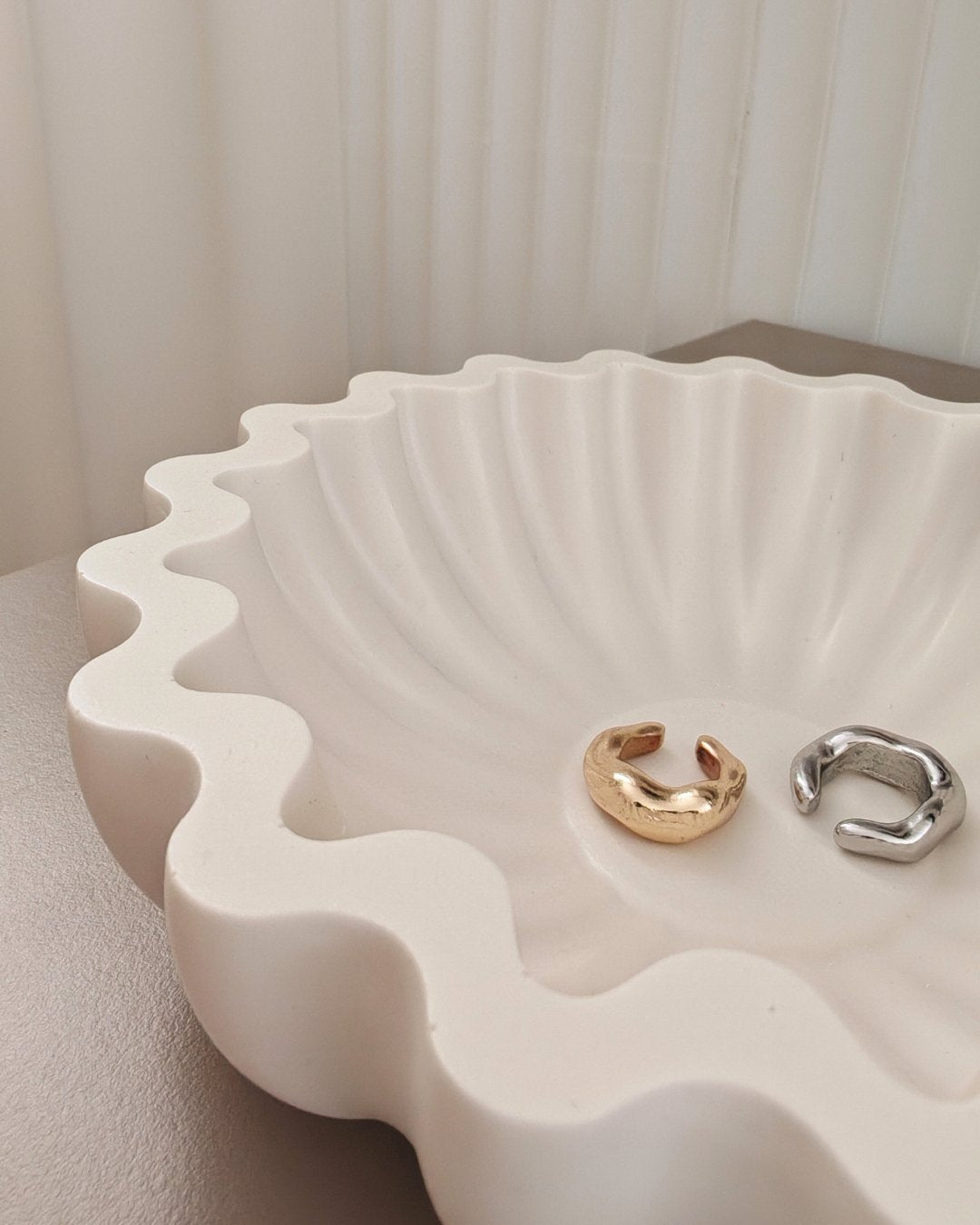 Porta gioielli Jesmonite bianco modello Aura con bordo ondulato, realizzato a mano da Aurah Lab, utilizzato come vassoio minimal per oggetti.